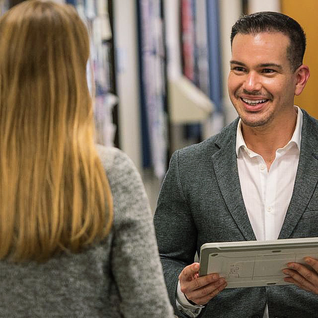 Dr. Rivera Pérez smiling during a conversation while holding a tablet